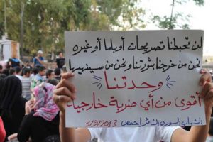Protest w kontrolowanym przez rebeliantów mieście Homs.  Napis: "Rozpoczęliśmy naszą rewolucję i ją zakończymy. Nasza jedność jest silniejsza od jakiegokolwiek obcego nalotu."
